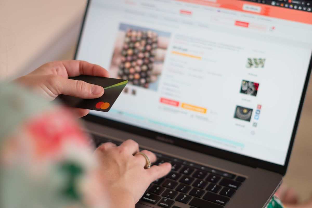 uomo che inserisce una carta di credito su un sito